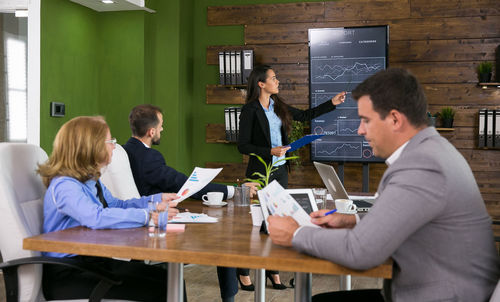 Businesswoman giving presentation to colleagues in office