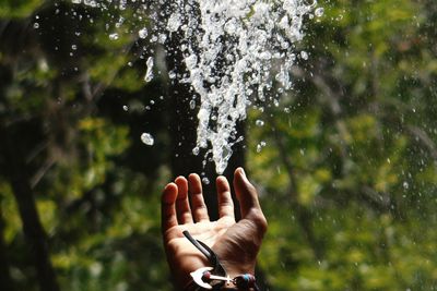 Close-up of human hand against blurred water