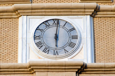 Low angle view of clock on brick wall