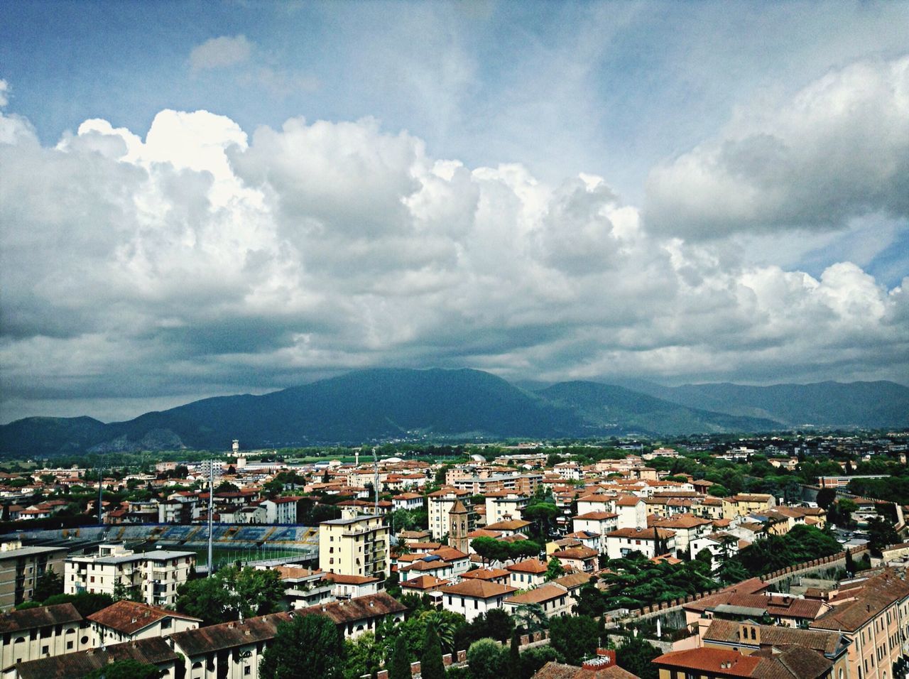 building exterior, architecture, built structure, mountain, sky, cityscape, cloud - sky, residential district, mountain range, high angle view, city, crowded, residential building, cloudy, house, town, residential structure, townscape, cloud, landscape