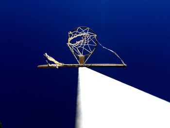 Low angle view of windmill against blue sky