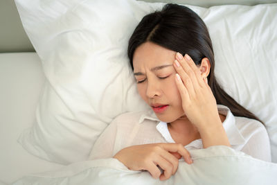 High angle view of woman sleeping on bed