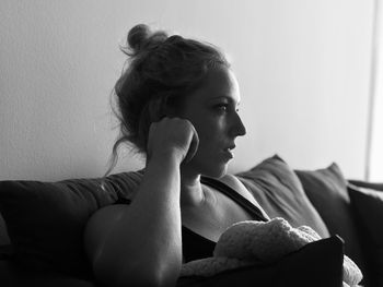 Close-up of woman sitting on sofa at home