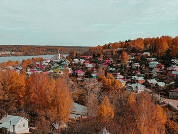 High angle view of townscape by sea against sky