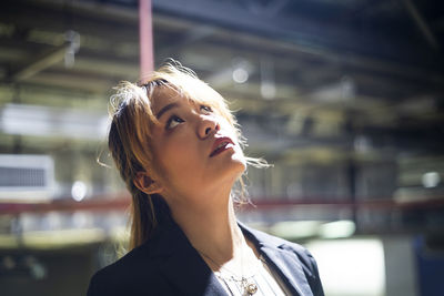 Close-up of thoughtful businesswoman looking up at station