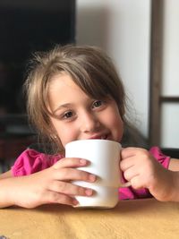 Portrait of girl having milk at home