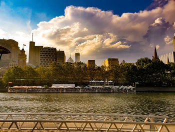 Scenic view of river by buildings against sky