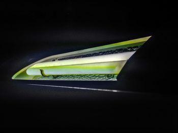 Close-up of green leaf on table against black background