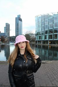 Portrait of woman standing against modern building in city