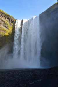 Scenic view of waterfall against sky