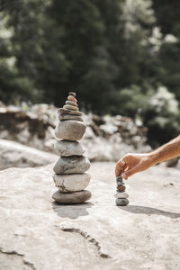 Hand of man stacking stones on rock