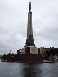 Statue by sea against sky