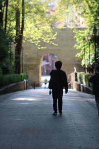 Full length rear view of silhouette man walking on footpath