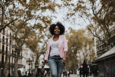 Carefree woman walking on street in city