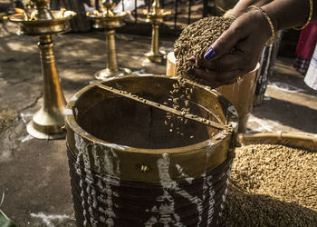 Person filling container with rice paddy.