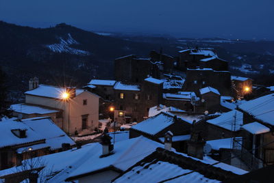 High angle view of illuminated buildings in city during winter at night