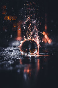 Close-up of water splashing in illuminated lights