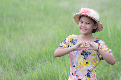 Smiling young woman wearing hat on field