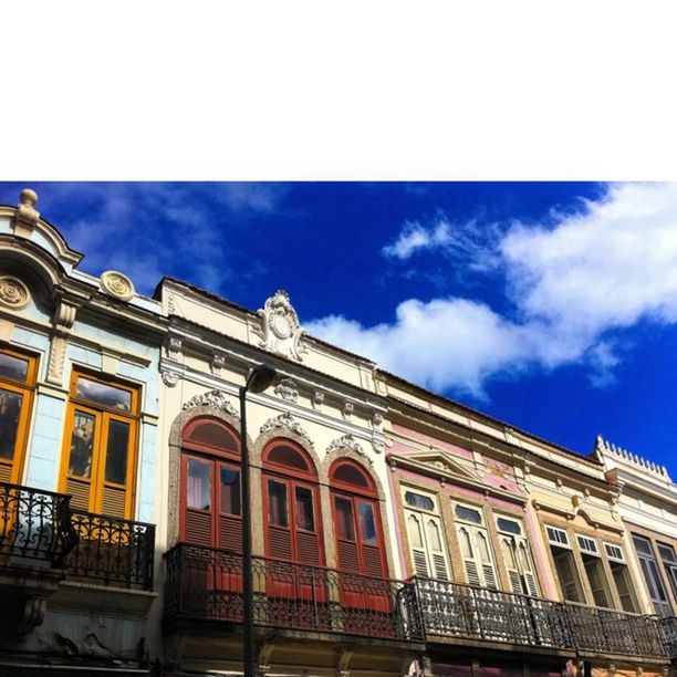 architecture, building exterior, built structure, low angle view, sky, window, cloud - sky, building, facade, cloud, city, arch, residential building, residential structure, day, outdoors, no people, high section, blue, cloudy