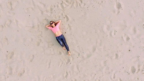 Low section of woman walking on sand at beach