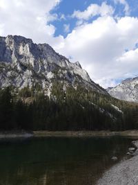 Scenic view of lake by mountains against sky