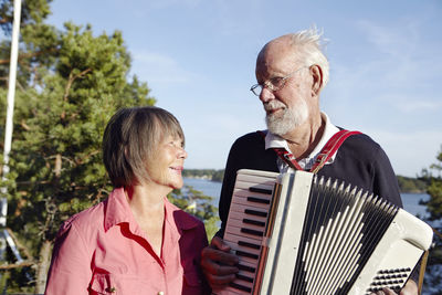 Senior man playing accordion to senior woman