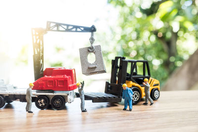 Close-up of figurines with toy crane and forklift on table