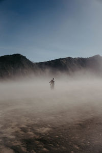 Man riding on mountain against sky