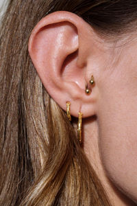 Close up of a woman ear with multiple earrings