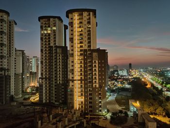 High angle view of illuminated buildings against sky at dusk