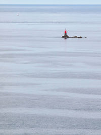 A lighthouse and a sail boat in the french sea of brittany 