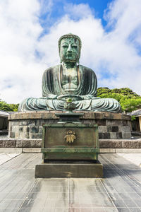 Statue of buddha against cloudy sky