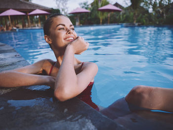 Smiling young woman in swimming pool