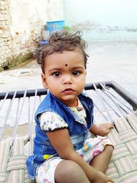 Portrait of cute girl sitting outdoors