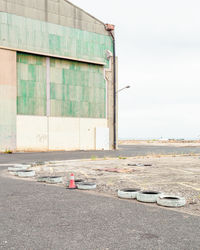 Abandoned building by road against sky in city