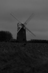 Traditional windmill on field against sky