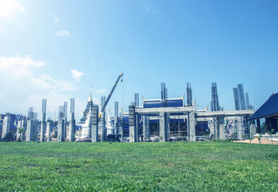 Panoramic shot of construction site by buildings against sky