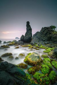 Scenic view of rocks in sea against sky