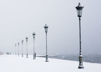 Street lights against clear sky during winter