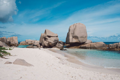 Rock formations on beach against sky