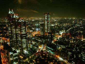 High angle view of illuminated buildings against sky at night