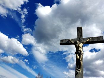 Low angle view of cross sculpture against sky