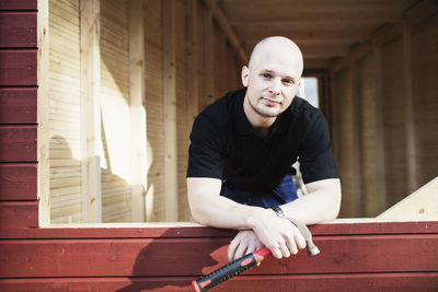 Portrait of confident carpentry teacher inside wooden cabin