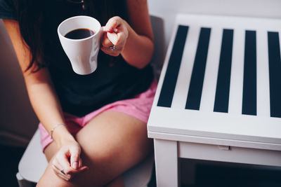 Midsection of woman holding coffee cup