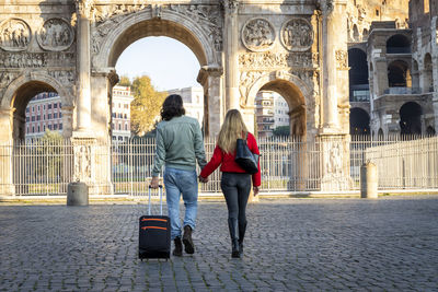 Young couple traveling to rome. the young couple is walking and holding hands. 