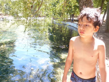 Portrait of shirtless boy standing in water