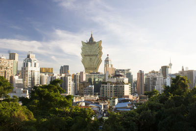 Buildings in city against cloudy sky