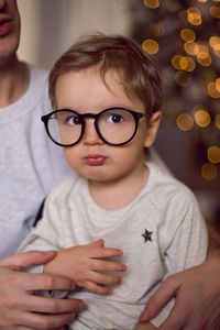 Father keeps the child in a t-shirt and glasses