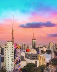 Modern buildings against sky during sunset