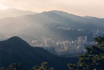 Buildings amidst mountains during foggy weather